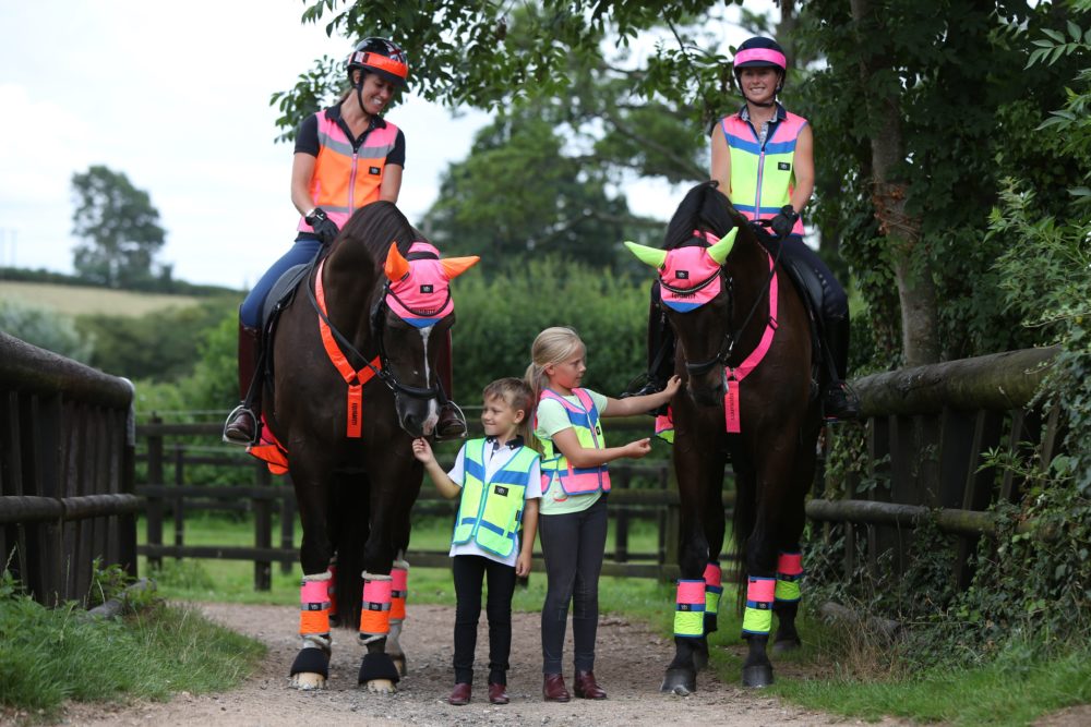 Equisafety - CD Multi-Colour Collection. Group of two women and young children and horses wearing Equisafety items