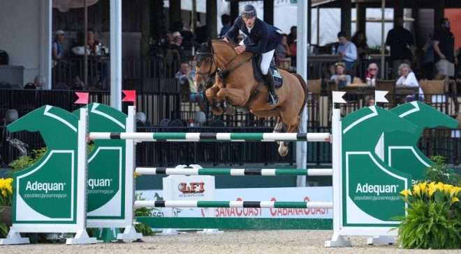 Richard Vogel and Caramba 92 catching air over the Adequan® jump. © Sportfot