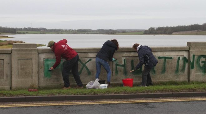 Hunt community volunteers clean up vandalism on bridge