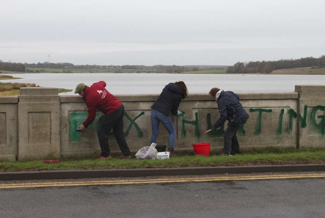 Hunt community volunteers clean up vandalism on bridge