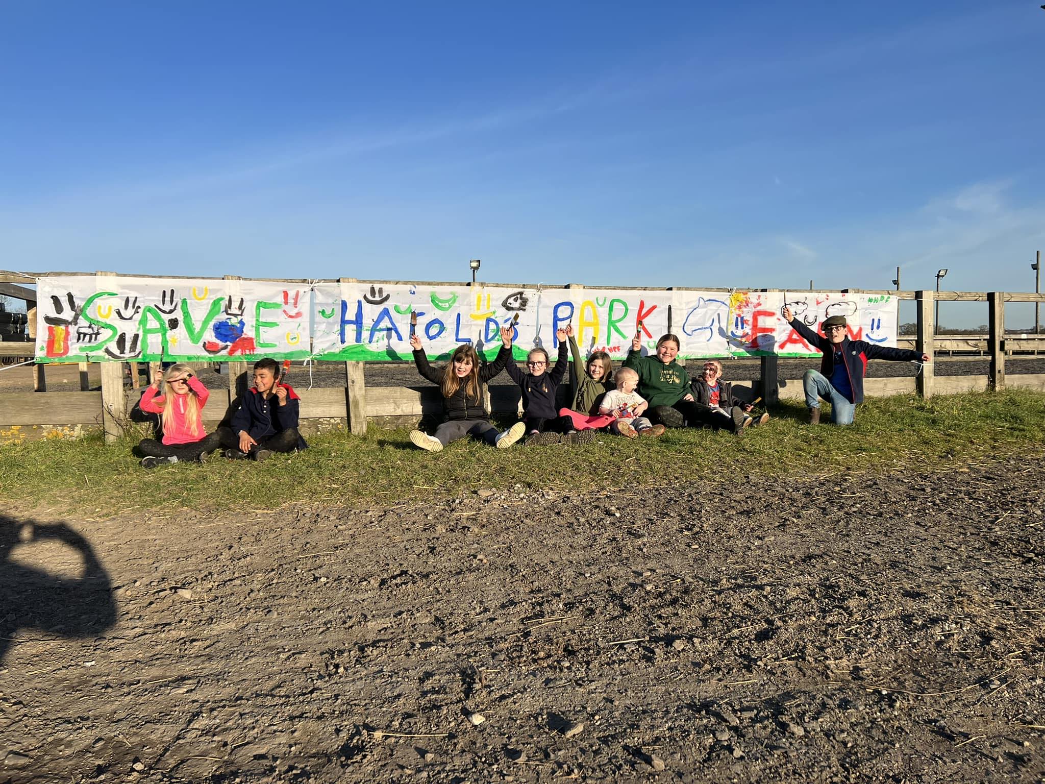 Harold's Park Farm children sitting in front of a banner marked save Harold's park farm