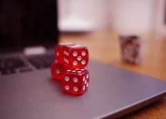 Betting on more than just horses: join the excitement in online casinos red dice on laptop