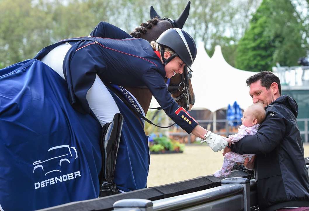 Charlotte Dujardin and Imhotep greeting her new daughter Isabella, after winning in The Defender CDI4* FEI Dressage Grand Prix at Royal Windsor Horse Show @RoyalWindsorHorseShow/Peter Nixon