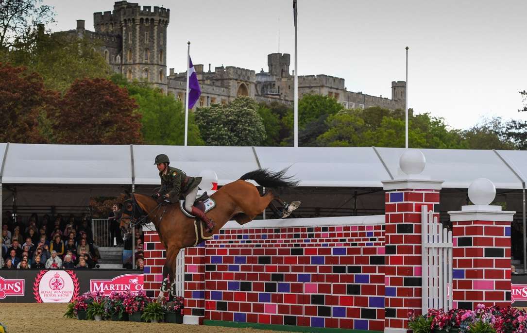 Commandant Geoff Curran clearing the Puissance wall at a final height of 2.12m, crowning him joint Champion of the Martin Collins Enterprises Puissance Jumping Competition @RoyalWindsorHorseShow/Peter Nixon