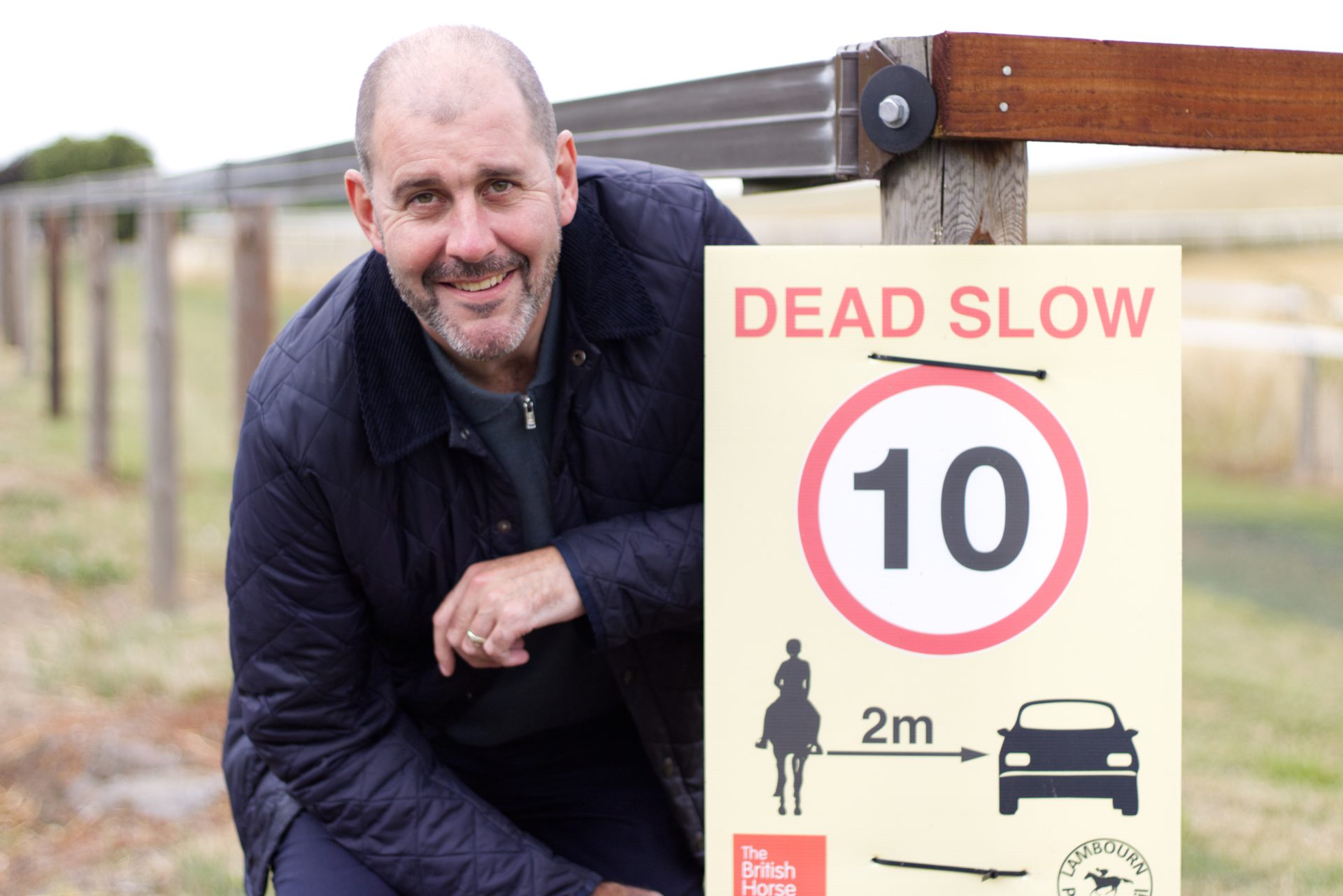 Lee Dillon MP stood next to an equestrian road safety sign displaying 10 mph