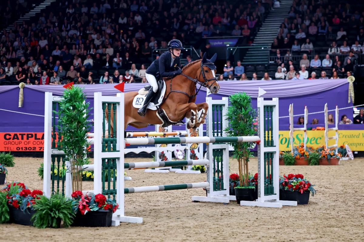 Raphaela Dawson doubles at HOYS with second major title riding in the STX-UK Pony Foxhunter Championship aboard MHS Glow. Image credit 1st Class Images This time it was Woody Van Duyversputten’s turn in the spotlight as Raphaela guided him to victory with an immaculate first round followed by a smooth, fast jump-off. A strong first round showcased the calibre of young riders rising through the ranks, with 11 combinations from 20 starters securing their place in the jump-off. Pony championships such as these provide valuable experience for riders aiming to progress onto the international circuit. William Whitaker, a previous Pony Foxhunter champion, and Jodie Hall McAteer, who enjoyed a successful pony career before moving into senior competition, illustrate where that pathway can lead. Raphaela’s time of 28.82 seconds secured victory ahead of Olivia Brightmore riding Flore Des Islots, with Portia Taylor-Wilson finishing third on Olivia W. The small chestnut gelding took the tight turns confidently, maintaining a smooth rhythm as Raphaela steered him around the course. “We’ve had the pony for five years now, and I am the only one who has ever jumped him in the ring,” Raphaela said. “When we first brought him home he used to go around our fields and jump the fences, so we always knew he could jump, but he was very difficult to break in, so he was actually kind of a year behind every other pony of his age.
